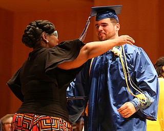 Robert Soto Jr. hugs Dean Monica Jones after receiving his high school diploma from Youngstown Early College graduation at Ford Recital Hall at DeYor Performing Arts Center, Sunday, May 7, 2017 in Youngstown. ..(Nikos Frazier | The Vindicator)