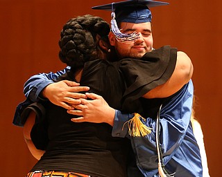 Robert Soto Jr. hugs Dean Monica Jones after receiving his high school diploma from Youngstown Early College graduation at Ford Recital Hall at DeYor Performing Arts Center, Sunday, May 7, 2017 in Youngstown. ..(Nikos Frazier | The Vindicator)