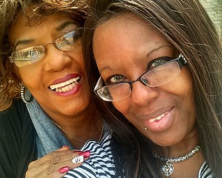 Elder Rosetta Carter embraces her daughter, Taunya Bourne, both of Youngstown.