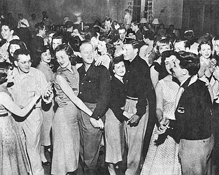 Vindicator file photo | May 16, 1954A good deal of the credit for the exceptionally high morale and fine records at the Air Force‚Äôs jet air base at the Youngstown Municipal Airport can go to the Youngstown -Mahoning County USO Committee which has gone all out to keep the enllisted men entertained with weekly dances, dinners and other entertainment. Most popular is the junior hostess program sponsored jointly with with YWCA and and the recent dance brought out the enlisted men in droves to dance with pretty girls, watch a floor show and enjoy a midnight snack. Above, City Park Supt. Tom Pemberton (center) helps entain the servicemen.