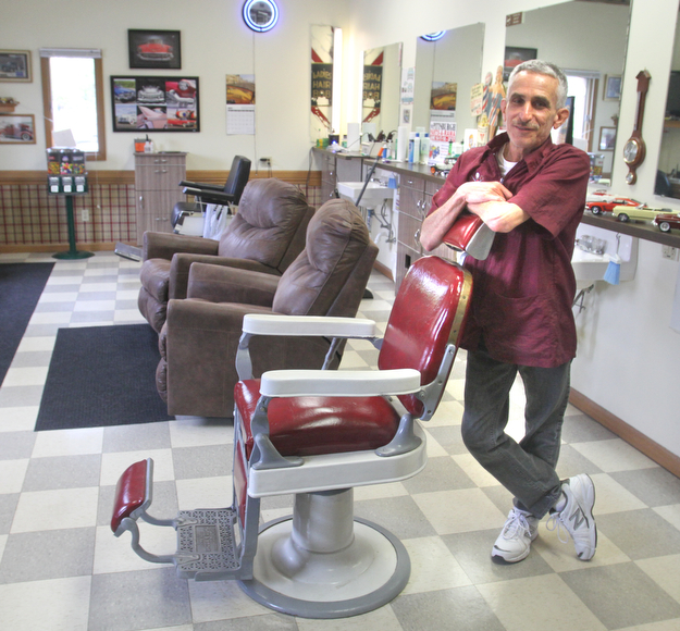 William D. Lewis The Vindicator Barber Bob Leonelli stands near an antique barberchair  in his Boardman barbershop.