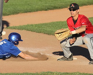 William D. Lewis The Vindicator  Poland's Ian Lu(5) dives back to first as Canfield'sSpencer Woolley(2) waits for the throw during 5-15-17 game at cene..