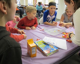 Neighbors | Alexis Bartolomucci.Poland librarian, Annette Ahrens, and the children tried to make Starbursts candies float in water during the Sweet Science program at the Poland library on April 13.