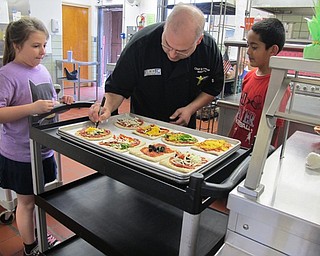 Neighbors | Alexis Bartolomucci.MCCTC Chef Sean Kushma wrote the names of the students by their pizza before the baked them for the Tot Chef program on April 27 at Market Street Elementary.