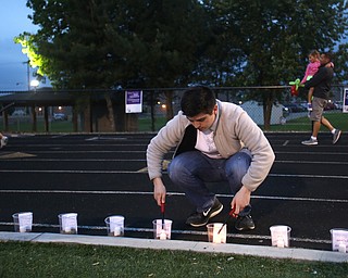 Laurence Bucciarelli of Canfield uses a lighter to light candles during the Relay for Life event at Boardman Spartan Stadium, Friday, May 19, 2017 in Boardman. ..(Nikos Frazier | The Vindicator)