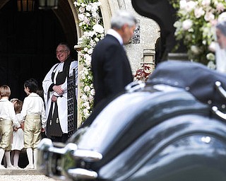 Kate, Duchess of Cambridge, left, stands with her daughter Princess Charlotte, bottom left, as they arrive for the wedding of Pippa Middleton, right, and James Matthews at St Mark's Church in Englefield Saturday, May 20, 2017. Middleton, the sister of Kate, Duchess of Cambridge is to marry hedge fund manager James Matthews in a ceremony Saturday where her niece and nephew Prince George and Princess Charlotte are in the wedding party, along with sister Kate and princes Harry and William. (AP Photo/Kirsty Wigglesworth, Pool)