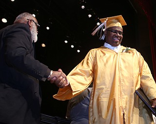 Taj Harper shakes board president Robert Faulkner Sr.'s hand after receiving his diploma during the Warren G. Harding High School Commencement at W.D. Packard Music Hall, Thursday, May 25, 2017 in Warren.  ..(Nikos Frazier | The Vindicator)