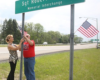 Chris(left) and Bill Wortman of Champion place flags on the Sgt. Robert M. Carr Memorial Interchange sign, Wednesday, May 17, 2017 on Route 5 in Warren. ..(Nikos Frazier | The Vindicator)