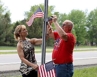 Chris(left) and Bill Wortman of Champion place flags on the Sgt. Marco Miller Memorial Interchange sign, Wednesday, May 17, 2017 on Route 5 in Warren. ..(Nikos Frazier | The Vindicator)