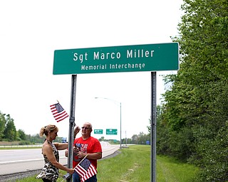 Chris(left) and Bill Wortman of Champion place flags on the Sgt. Marco Miller Memorial Interchange sign, Wednesday, May 17, 2017 on Route 5 in Warren. ..(Nikos Frazier | The Vindicator)