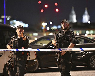 Armed Police officers stand guard on London Bridge in central London, Saturday, June 3, 2017.  British police said they were dealing with "incidents" on London Bridge and nearby Borough Market in the heart of the British capital Saturday, as witnesses reported a vehicle veering off the road and hitting several pedestrians. (Dominic Lipinski/PA via AP)