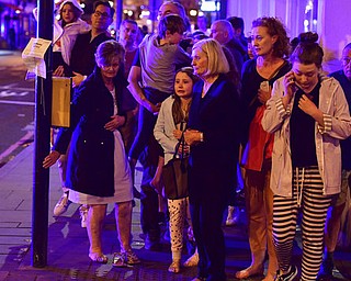 People walking down Borough High Street as police are dealing with an incident on London Bridge in London, Saturday, June 3, 2017.    Witnesses reported a vehicle hitting pedestrians and injured people on the ground. (Dominic Lipinski/PA via AP)