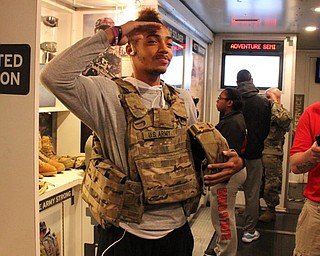 Neighbors | Abby Slanker.A Mahoning County Career and Technical Center student tried on the soldier plate carrying system, which weighs 25 pounds, during a visit to the Army Adventure Semi AS1 on May 2.