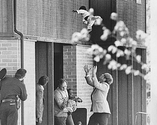 PAUL R. SCHELL | VINDICATOR FILE PHOTO
Carla Blair-Bohannon drops one of her children from a window while being held hostage by a bank-robbery suspect in 1977. Blair-Bohannon later escaped the ordeal. 