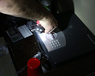 A police officer searches a safe with the confiscated keys of the suspect as Youngstown Police search a house on the 200 block of E Judson Ave, Thursday, June 1, 2017 in Youngstown...(Nikos Frazier | The Vindicator)
