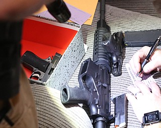 Police officers catalog firearms found as Youngstown Police search a house on the 200 block of E Judson Ave, Thursday, June 1, 2017 in Youngstown...(Nikos Frazier | The Vindicator)