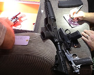 Police officers catalog firearms found as Youngstown Police search a house on the 200 block of E Judson Ave, Thursday, June 1, 2017 in Youngstown...(Nikos Frazier | The Vindicator)