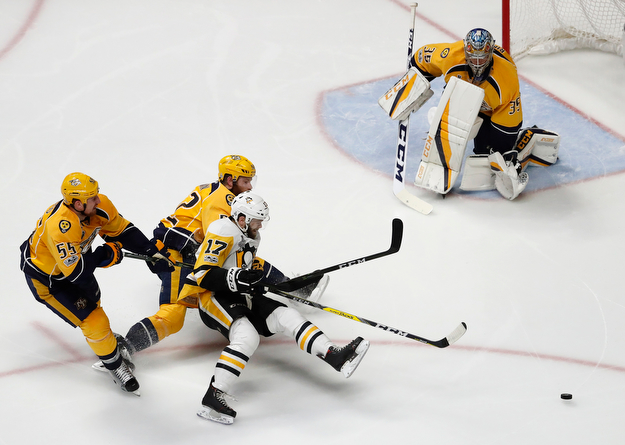Pittsburgh Penguins' Bryan Rust (17) battles for the puck against Nashville Predators's Cody McLeod (55) and Matt Irwin (52) as Nashville Predators goalie Pekka Rinne (35), of Finland, guards the goal during the second period of Game 6 of the NHL hockey Stanley Cup Final, Sunday, June 11, 2017, in Nashville, Tenn. (AP Photo/Jeff Roberson)