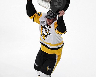 Pittsburgh Penguins' Sidney Crosby (87) hoists the Stanley Cup after defeating Nashville Predators in Game 6 of the NHL hockey Stanley Cup Final, Sunday, June 11, 2017, in Nashville, Tenn. (AP Photo/Jeff Roberson)
