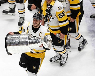 Pittsburgh Penguins' Sidney Crosby (87) celebrates with the Stanley Cup after defeating the Nashville Predators in Game 6 of the NHL hockey Stanley Cup Final, Sunday, June 11, 2017, in Nashville, Tenn. (AP Photo/Jeff Roberson)
