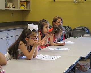 Neighbors | Alexis Bartolomucci.Girls at the dandelion Sprout Club blew the seeds of a dandelion during the program at Fellows Riverside Gardens on May 18.