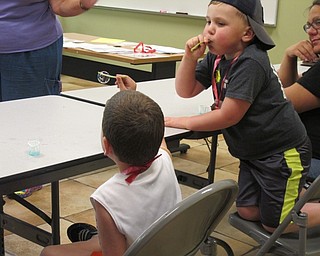 Neighbors | Alexis Bartolomucci.Children blew bubbles using dandelion stems and soap mixed with water during Fellows Riverside Gardens Sprout Club.
