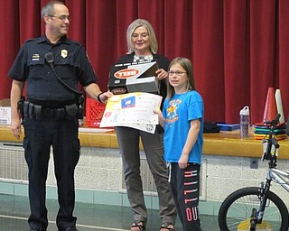 Neighbors | Alexis Bartolomucci.Robinwood Lane student, Alaura Malich, received a helmet and Dairy Queen gift card from Sgt. Chuck Hillman and Nancy Hildebrand both of the Boardman Optimist Club for her bike safety poster she made.