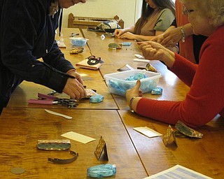 Neighbors | Alexis Bartolomucci.Guests worked with each other on May 26 at the Austintown library to create the mini bag during the paper craft program.