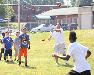 YSU Football head coach Bo Pelini passes the ball to Jaden Payne(11) of Boardman during the Cardinal Mooney Football Camp at Cardinal Mooney High School, Thursday, June 22, 2017 in Youngstown...(Nikos Frazier | The Vindicator)
