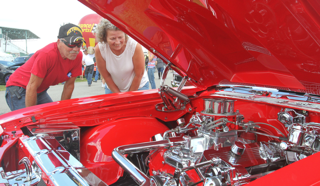 William D. Lewis The Vindicator Doug and Tina Williams of Lisbon look under the hood of a 1970 Chevy Monte Carlo at Hot Rod Super Nationals 6-24-17 at the Canfield Fairgrounds.