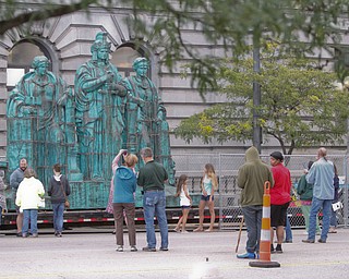     ROBERT K. YOSAY  | THE VINDICATOR..the newly-restored copper statues were returned to its roof of the courthouse..The statues, removed in October 2010, have been returned to their perch above the courthouse's main entrance where they had sat since 1909...The three hollow statues, which were restored by an Oberlin firm, are named ÒJustice,Ó on the left, ÒStrength and AuthorityÓ in the center; and ÒLawÓ on the right.