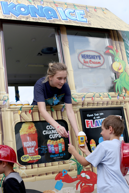 Zoe Oswald of Kona Ice hands an ice cup to Kyle Johnston(9) of Youngstown during the 19th annual Struthers Day at Mauthe Park, Thursday, June 29, 2017 in Struthers...(Nikos Frazier | The Vindicator)