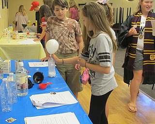 Neighbors | Alexis Bartolomucci.Children inflated a balloon using vinegar and baking soda while at the Hogwarts Summer School program on June 21 at the Poland library.