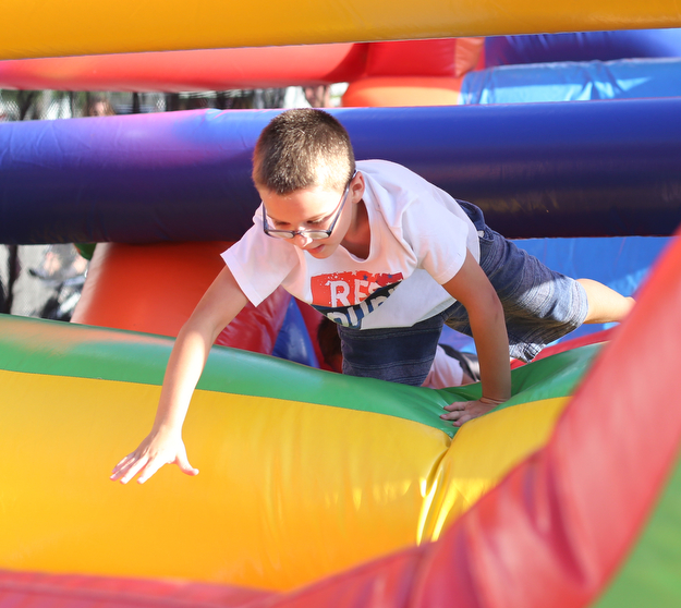 Shane Ashburn(7) of Boardman jumps through the 61 ft obstacle bounce house during the Canfield Rotary Fireworks Fest at the Canfield Fair Grounds, Saturday, July 1, 2017 in Canfield...(Nikos Frazier | The Vindicator)