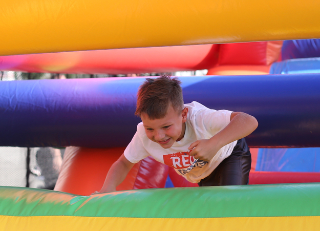 Dominic Krut(7) of Boardman jumps through the 61 ft obstacle bounce house during the Canfield Rotary Fireworks Fest at the Canfield Fair Grounds, Saturday, July 1, 2017 in Canfield...(Nikos Frazier | The Vindicator)
