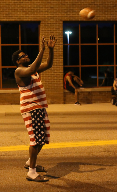Justin Howard of Youngstown plays catch with a football before the Fourth of July Fireworks at the Covelli Centre, Tuesday, July 4, 2017 in Youngstown...(Nikos Frazier | The Vindicator)