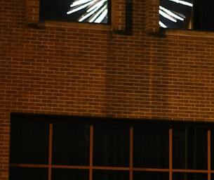 A group watches the fireworks display as the explosion is reflected in the window of a Front St. business during the Fourth of July Fireworks at the Covelli Centre, Tuesday, July 4, 2017 in Youngstown...(Nikos Frazier | The Vindicator)