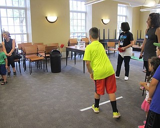 Neighbors | Alexis Bartolomucci.Children lined up to play a toss the poop game where they had to throw a bean bag into the trash can during the Captain Underpants program.