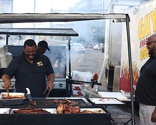 Sean Hughes, the everything man at Guy's Award Winning BBQ Sauce, serves Cameron Jackson of Warren during the Youngstown Jazz and Wine Fest, Saturday, July 8, 2017 in Central Square in downtown Youngstown...(Nikos Frazier | The Vindicator)