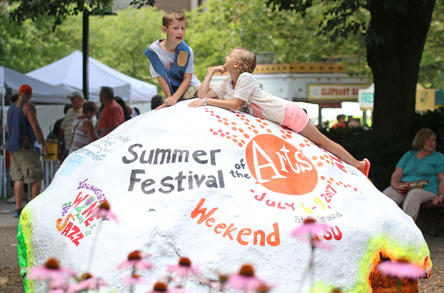 Alec Toporcer (7) and his sister Halle (9) Toporcer of Canfield sit atop the rock at Youngstown State University during the Summer Festival of the Arts on Saturday afternoon.  Dustin Livesay  |  The Vindicator  7/8/17  Youngstown State University.