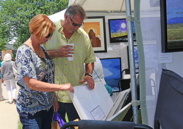 L-R) Sue Greaves of McDonald browses photographswith Joe Mozzy of Boardman during the Summer Festival of the Arts at Youngstown State University on Saturday afternoon.  Dustin Livesay  |  The Vindicator  7/8/17  Youngstown State University.