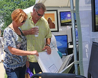 L-R) Sue Greaves of McDonald browses photographswith Joe Mozzy of Boardman during the Summer Festival of the Arts at Youngstown State University on Saturday afternoon.  Dustin Livesay  |  The Vindicator  7/8/17  Youngstown State University.