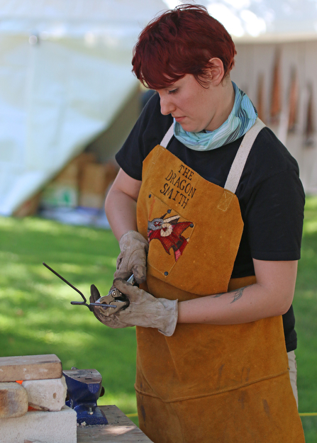 Lizz Betz of "The Dragon Smith" of Niles creates a cross made of steel during the Summer Festival of the Arts at Youngstown State University on Saturday afternoon.  Dustin Livesay  |  The Vindicator  7/8/17  Youngstown State University.