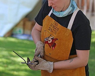 Lizz Betz of "The Dragon Smith" of Niles creates a cross made of steel during the Summer Festival of the Arts at Youngstown State University on Saturday afternoon.  Dustin Livesay  |  The Vindicator  7/8/17  Youngstown State University.