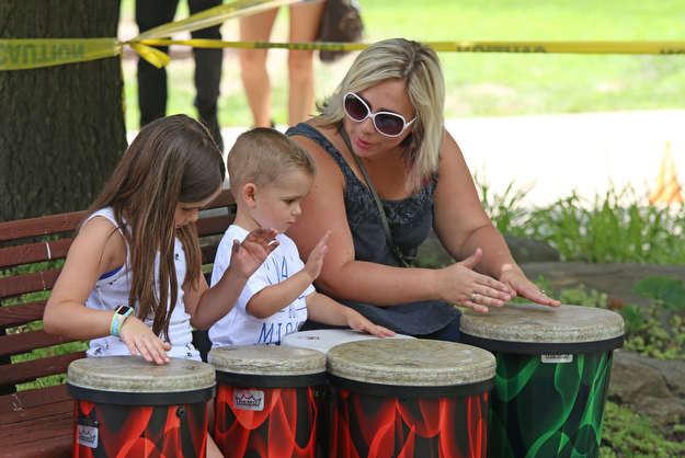 Kristin Newbrough (far right) plays on drums with her kids Evan (3) and Ella (7) all of Warren during the Summer Festival of the Arts at Youngstown State University on Saturday afternoon.  Dustin Livesay  |  The Vindicator  7/8/17  Youngstown State University.