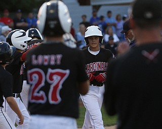 Canfield short stop Ben Slanker (14)(center) is met by cheering teammates on a three run home run in the second inning against Canfield/Poland, Sunday, July 9, 2017, at Fields of Dreams in Boardman. Canfield won 11-0...(Nikos Frazier | The Vindicator)..