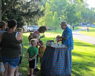 Neighbors | Alexis Bartolomucci.Jocko the Balloon Man made hats, swords and other objects out of balloons for the children at Family Night in the Park.