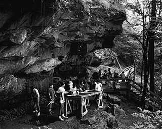 On the rocks: A large group of students looks for buried treasure under Umbrella Rock downstream from Lanterman's Mill in Mill Creek Park...(Vindicator file photo | Bob DeMay)