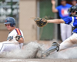 STRUTHERS, OHIO - JULY 23, 2017: Astro's Noah Laster, right, slides into home to score a run on a sacrifice fly by Craig Palidar, beating the tag from 96ers catcher Kace Garners, in the sixth inning of their game Sunday afternoon at Cene Park. The 96ers won 3-2. DAVID DERMER | THE VINDICATOR