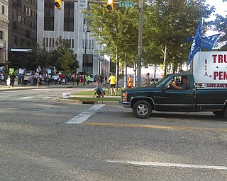 Guy trolls counter rally with this truck; man shouts "it's the devil's truck." Another driver flips him off.
